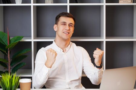 Relaxed businessman working with a laptop in his officeの写真素材