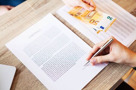 Businessman giving money while making deal to agreement a real estate contract and financial corporateの写真素材