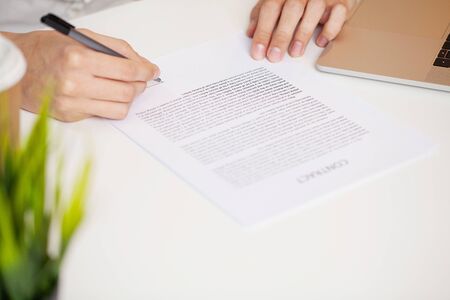 Businessman sitting at office desk signing a contractの写真素材