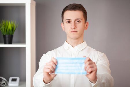 Man holding a protective mask against virus