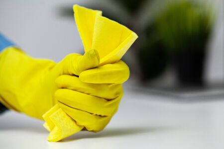 Closeup of worker hand wiping dust in office