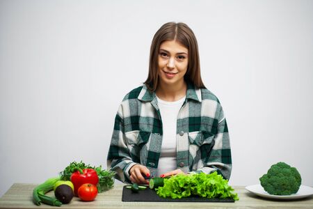 Concept of healthy eating and diet girl holding vegetables on background white wall