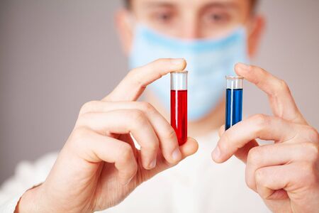 Health worker holds a test tube with a test of covid-2019.