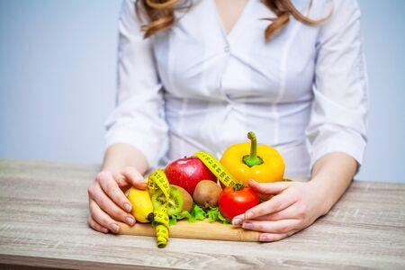 Doctor Nutritionist holding fresh fruits and vegetables for a healthy diet.の写真素材