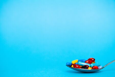 Spoon full of pills for weight loss on blue backgroundの写真素材