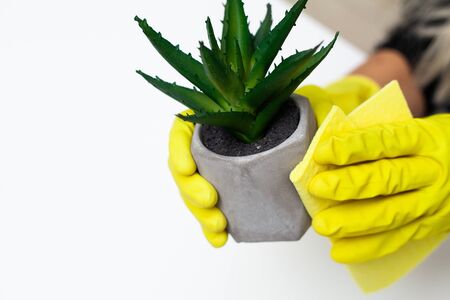 Close up of worker hand wiping dust in office in yellow gloves.