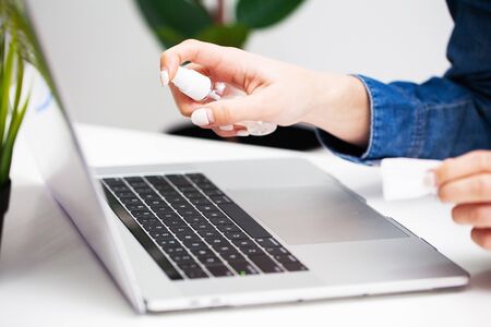 Woman in office uses antiseptic for disinfectionの写真素材