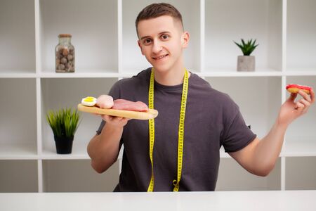 Strong man consumes a high-protein meal of meat and donut.の写真素材