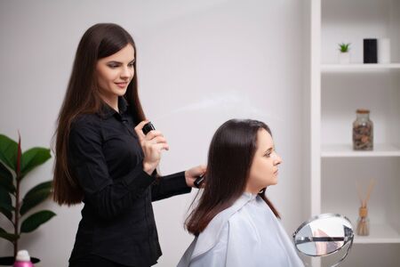 Professional hairdresser does hair care procedures at homeの写真素材