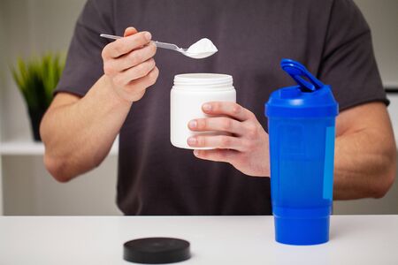 Man prepares a protein shake in the shaker after trainingの写真素材