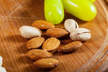 Nuts lie on a wooden kitchen board.の写真素材