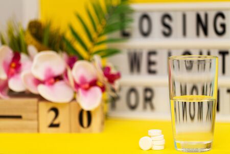 White weight loss pills on yellow backgroundの写真素材