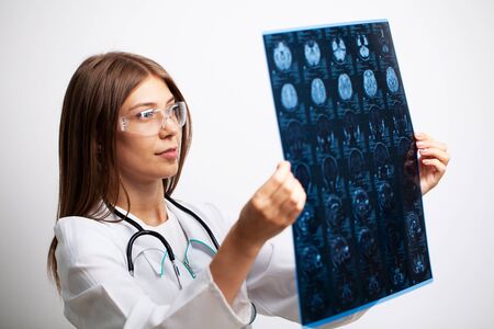 Doctor examines an MRI image of the patients headの写真素材