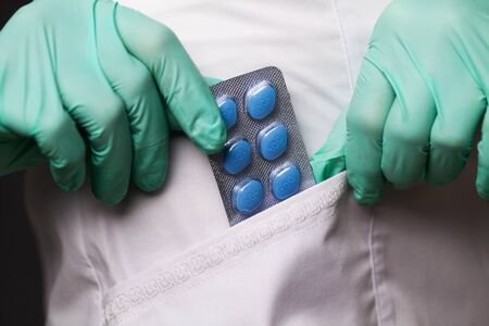 Female doctor in gloves holds pills for mens sexual health