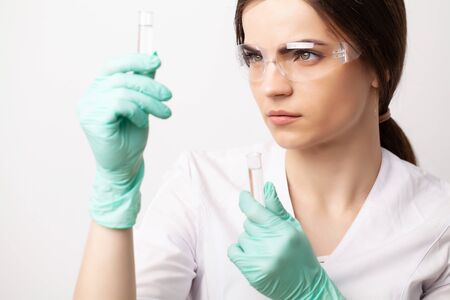 Female doctor in laboratory holding holding test tubes with experimental antiviral vaccineの写真素材