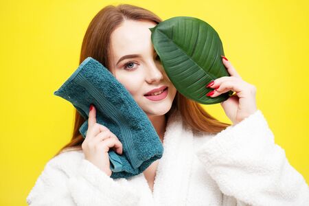 Young woman wipes face with soft towel after spa treatmentsの写真素材