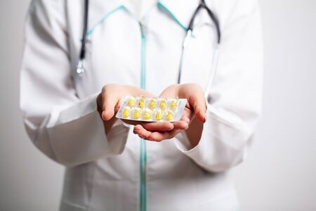 Female doctor holding pills in her handsの写真素材