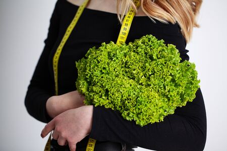 Diet concept, woman holding green broccoli measuring tape.の写真素材