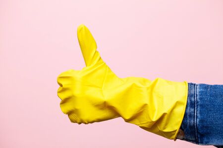 Hand in a yellow glove for cleaning.