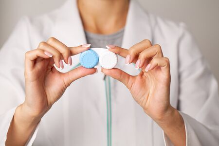 Doctor holding a container with contact lenses.