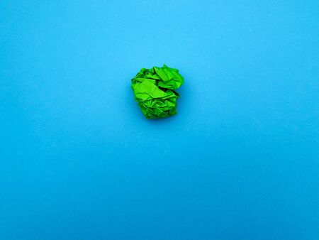 Successful idea concept, green crumpled sheet of paper on blue background.の写真素材