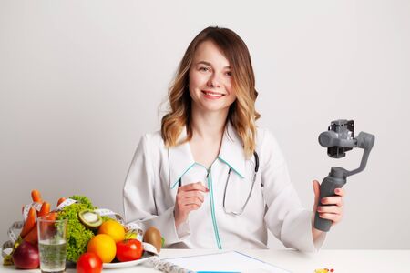 Nutritionist records a video blog about healthy eating on a mobile phoneの写真素材