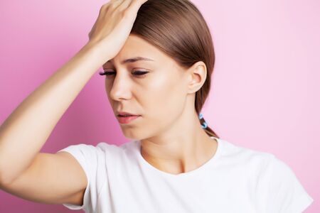 Head pain, exhausted young woman has suffering from unbearable headacheの写真素材