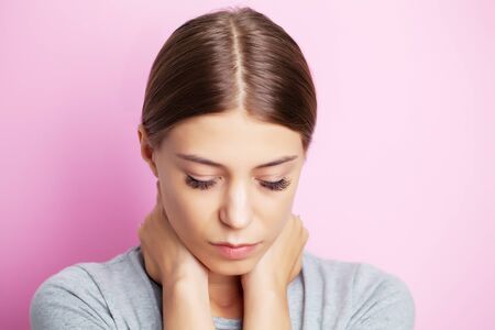 Exhausted young woman suffering from severe neck pain