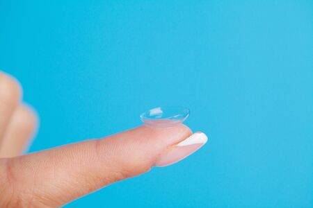 Solving vision problems, close up of woman holding contact lens.の写真素材