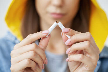 Stop smoking, close up of woman breaking cigarette