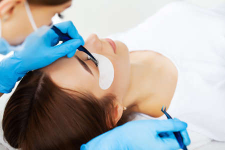 Young woman in a beauty studio on an eyelash extension procedure