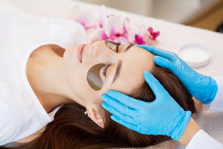 Master and client in a beauty salon, patches for skin care under the eyesの写真素材
