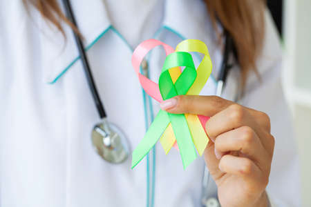 Female doctor holds colored ribbons symbolize awareness of various diseases