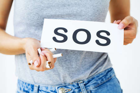 Stop smoking, young girl holding broken cigarette in hands.の写真素材