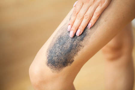 Skin care, woman applies black scrub with sea saltの写真素材