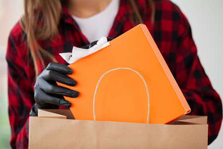 Woman disinfects parcels before unpacking at home