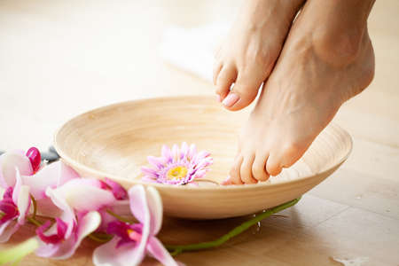Closeup photo of a female feet at spa salon on pedicure procedureの写真素材