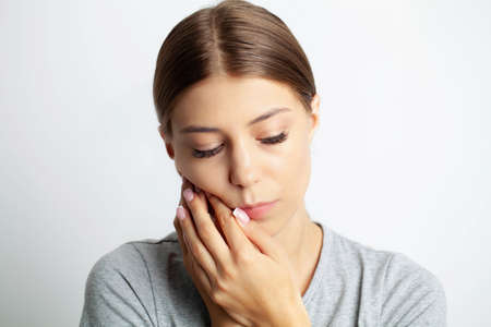Close up of a beautiful young woman experiencing a painful toothacheの写真素材