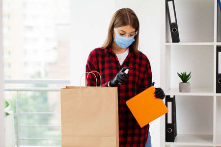 Woman disinfects parcels before unpacking at home.