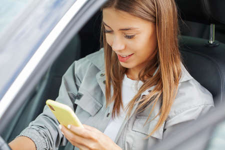 Woman holding smartphone, typing message, chatting with friends in social networks
