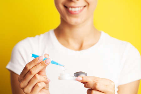 Closeup Of Woman Hands Holding White Eyelense Container