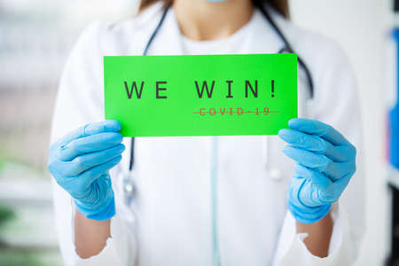 Covid-19, doctor holds a form with the text we winの写真素材