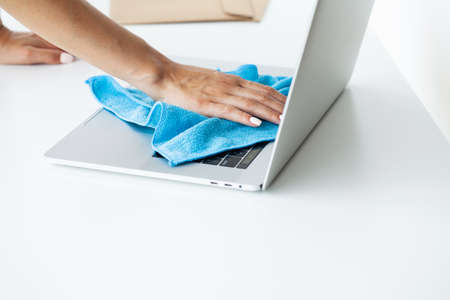 Cleaner tidies up the computer desk in the office.の写真素材