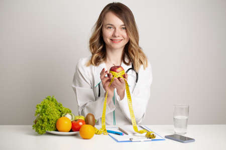 Young nutritionist doctor writing diet plan, healthy eatingの写真素材
