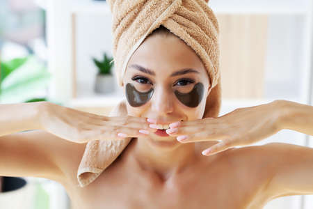Portrait of beauty woman with eye patches showing an effect of perfect skin.の写真素材