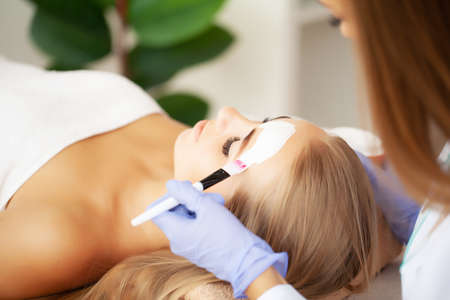 Beautiful woman with facial mask at beauty salon