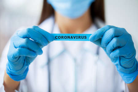 octor holding a paper card with text covid-19
