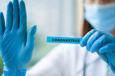 octor holding a paper card with text covid-19の写真素材
