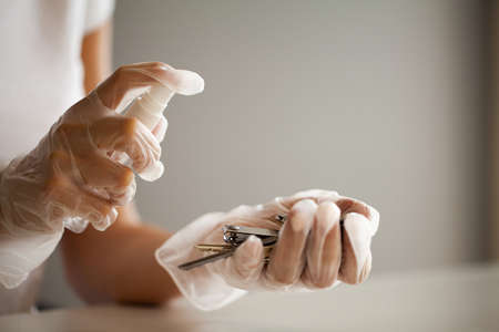 Woman disinfecting keys with disinfectant on the table