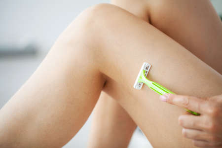 Skin care and health, fit woman shaving her legs with razor.の写真素材